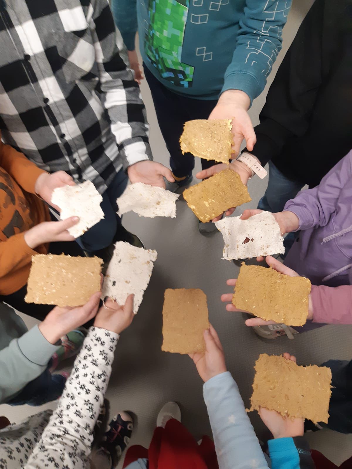 Pirmklasnieki rada papīru no piepēm